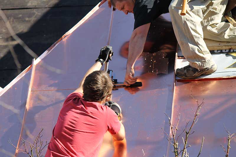 Metal roofing contractor working on new roof installation